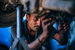 mechanic working on underside of car